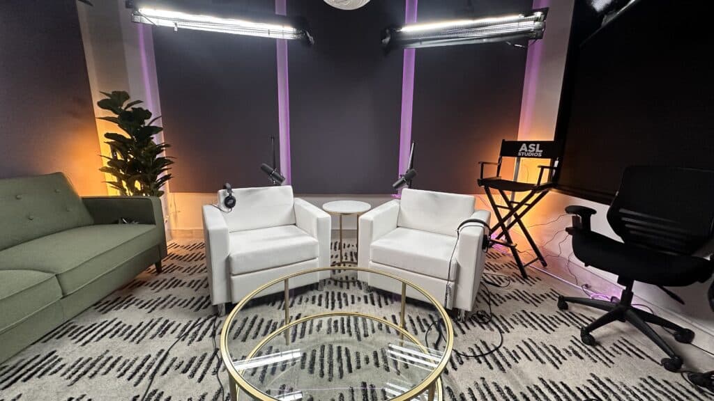 BTS white chair set with colorful custom lighting in background in ASL studios video podcast room