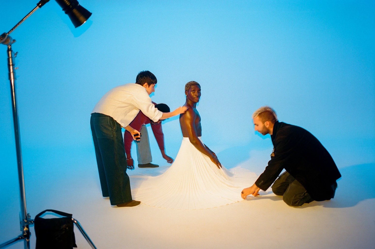 Photo shoot at ASL Studios model in white flowing dress being worked on by wardrobe