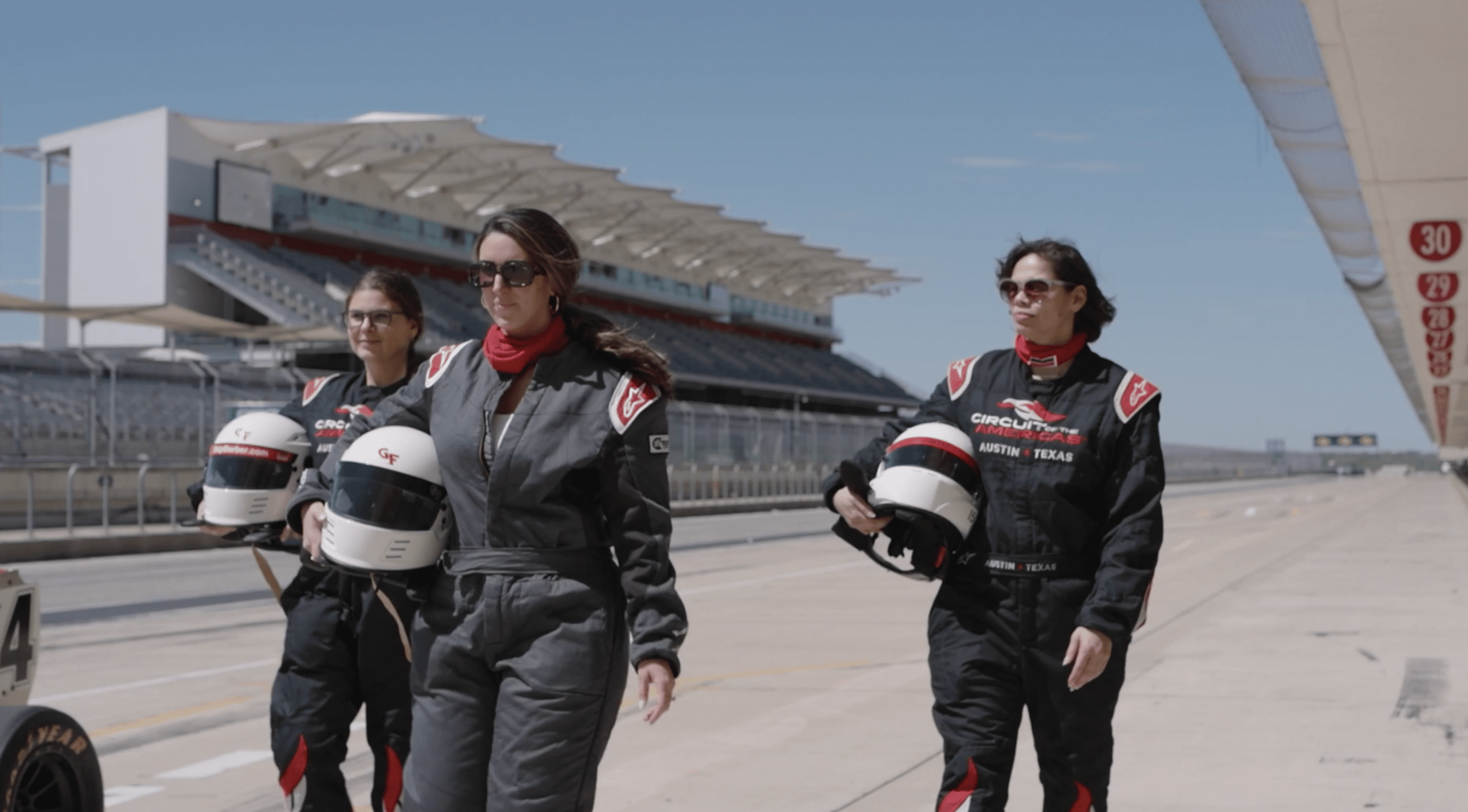 women at an experiential event at SXSW in racing gear and helmets on the track