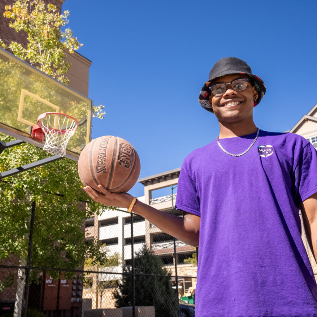 Basketball player at yugo property on the court holding a ball for the real estate video and photo content